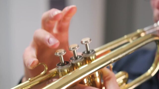Close-up , man playing the trumpet indoors, with puffed cheeks and intense focus, shiny brass instrument, his hands on the valves, and expressive facial details during performance.