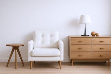 Minimalist interior scene featuring a white tufted armchair, wooden side table, and a modern dresser with a lamp and decorative spheres.