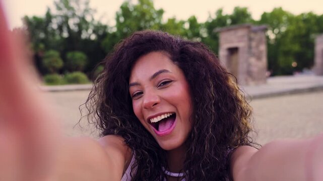 Young tourist smiling while taking selfies at the Temple of Debod
