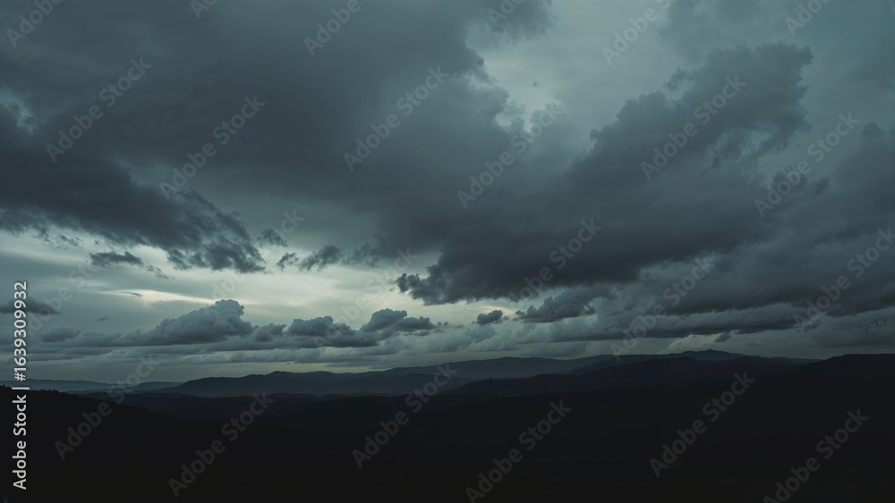 Wall mural overcast sky with dark hills creating an abstract background