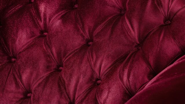 Detailed close-up of velour material with buttoned quilting on furniture upholstery.