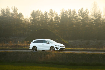 White sports wagon driving rural road