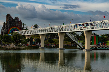 Obraz premium Mini park train riding on a small decorative bridge.