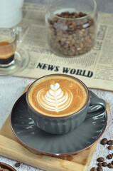 Cup of hot cappuccino coffee with beautiful latte art in a beautiful glass on the table