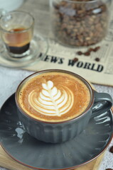 Cup of hot cappuccino coffee with beautiful latte art in a beautiful glass on the table