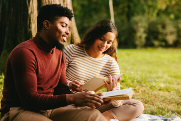 Students reading books and enjoying autumn day in park