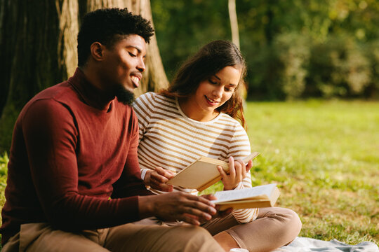 Students reading books and enjoying autumn day in park