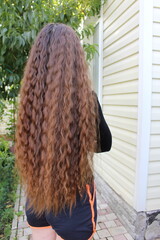 The girl has very beautiful long curly hair.