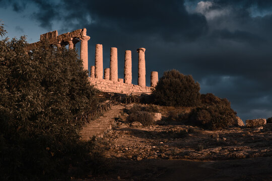 Ruins of ancient greek Tempio di Giunone in Valle dei Templi illuminated at sunset, Agrigento, Italy