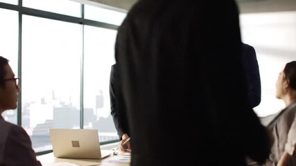 A diverse team of business professionals collaborating during a presentation, discussing data analysis and strategic planning in a modern environment. - Powered by Adobe