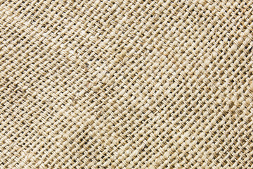 Natural jute fabric texture closeup. Woven burlap surface with coarse fibers in beige color. Rustic textile background for eco design, crafts, and packaging concepts. Organic material pattern.