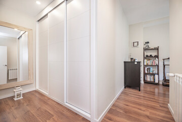 Elegant master bedroom with a white wood wardrobe and gold details that provide luxury and functionality