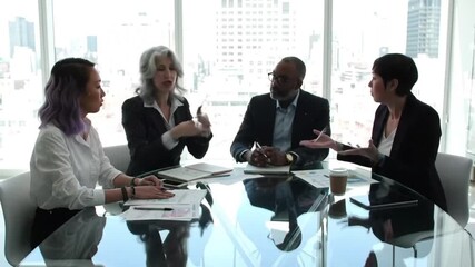 A diverse group of professionals collaborates around a reflective glass table during a business meeting, discussing ideas and strategies. - Powered by Adobe