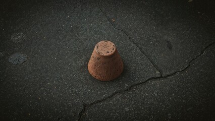 Brick piece shaped as a reverse cone placed on aged asphalt