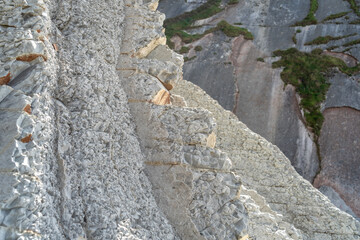 Layered rocks, flysch texture background. Sedimentary rock, striations stone pattern