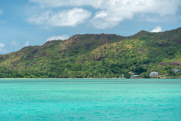 View of green hills and turquoise waters off Praslin Island, Seychelles
