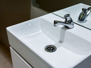 Modern white ceramic sink with chrome faucet in minimalist bathroom setting