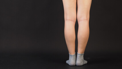 Male legs wear grey sock is isolated on black background.