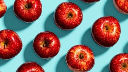 Colorful arrangement of fresh red apples on a turquoise background highlighting their natural beauty and vibrant hues