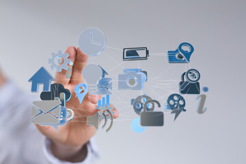 Hand interacting with digital icons representing a network of applications and devices.  Modern technology concept.