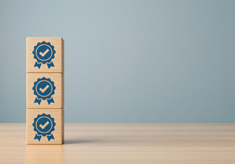 Stack of wooden cubes with quality standard icons, symbolizing product excellence, compliance, and certification with copy space.