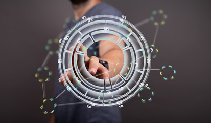 A man interacts with a holographic circular data display, showcasing modern technology and data analysis.