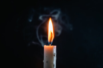 Single candle flame flickering against dark background, creating a peaceful and contemplative...