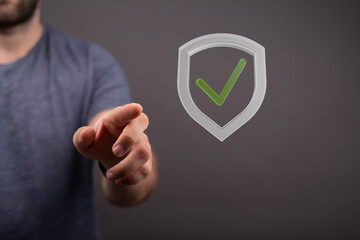 Hand reaching for a digital shield with a checkmark, symbolizing data protection and security.