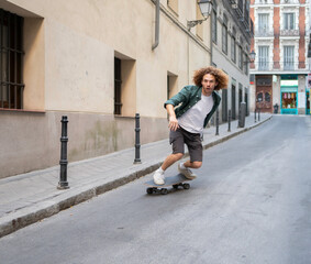 Stylish man skateboarding downhill in urban environment, enjoying outdoor activity and showcasing youthful energy © VictorCanalesStudio