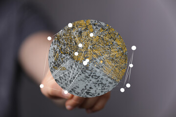 High-quality stock photo of a hand holding a digital globe showing interconnected cities.