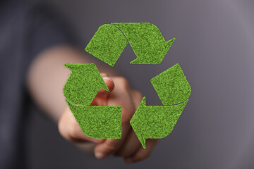 Hand interacting with a green recycle symbol. Eco-friendly concept.