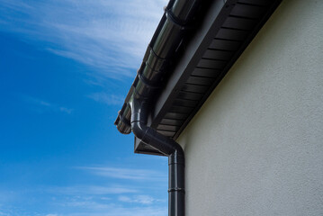 Plastic rain gutter on house eaves © Sergey