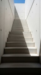 Fototapeta premium Modern concrete staircase with dramatic light and shadow, architectural design element