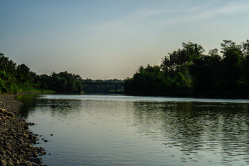 Peaceful River Scene with Pebble-Laden Shore