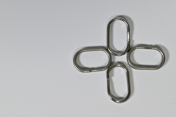 Metal oval clips arranged in a cross shape on white background