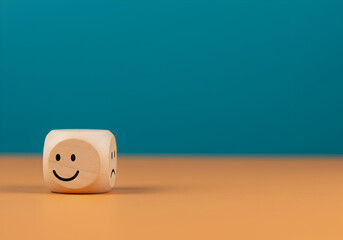 Smiling face icon on a wooden cube. A happy emoticon is shown on a block, symbolizing positive feelings, customer satisfaction, a good review, or a state of well-being, with copy space for text.