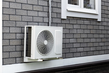 the external unit of the air conditioner is attached to the wall of the house. outdoor air conditioner unit. air conditioning system of a residential building. external air conditioner unit