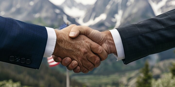 Businessmen shaking hands with american flag and mountain landscape background