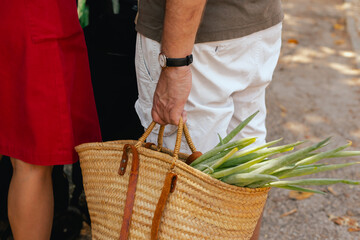 Close up of hand with a vegetables and greens in shopping basket on the local Farmers market....