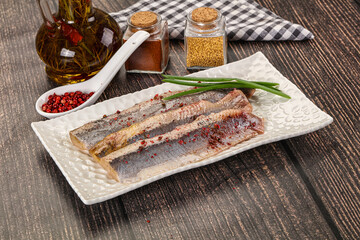 Salted marinated herring fillet with spices