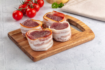 Raw pork tenferloin with bacon
