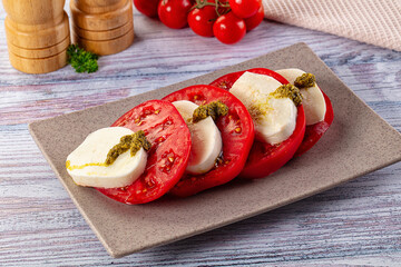Italian Caprese salad with tomato, mozarella and pesto
