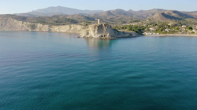 Aerial view of the antique defense watchtower of Cala del Charco, in Campello over the border of cliff in Mediterranean Sea, Alicante, Spain.