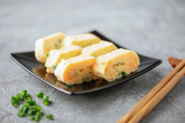 Tamagoyaki, Japanese rolled omelette in plate on the table