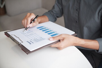 Closeup hand of  businessman reading report in office