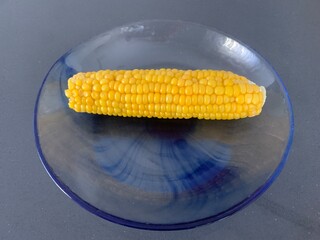 Closeup image of a corn on the cob on a blue plate