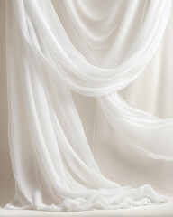 Flowing white sheer fabric draped elegantly, creating soft folds and textures against a neutral background.