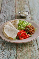 ground pork taco wraps with lettuce, tomato, and flour tortillas