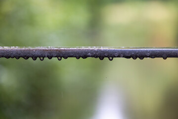Raindrops hanging from metal bar, Germany, Augsburg, 21 July 2025