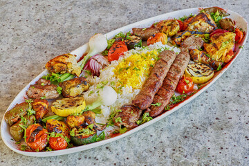 meat kebab with lamb, beef, pork, and chicken with mixed vegetables and yellow rice